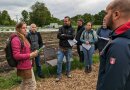 Teilnehmende des Treffens vor einem Feld der Solidarischen Landwirtschaft