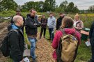 Teilnehmende des Treffens vor einem Feld der Solidarischen Landwirtschaft